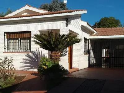 a white house with a palm tree in front of it at Casa Josefina in Merlo