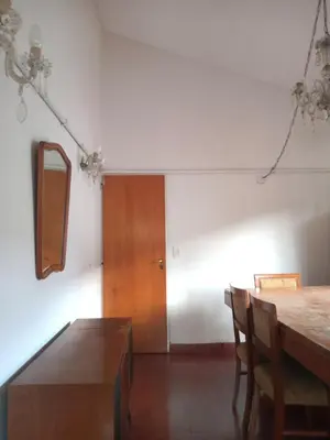 a dining room with a table and a wooden door at Casa Josefina in Merlo