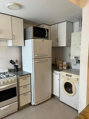 a kitchen with a refrigerator and a washing machine at Departamento Andy in Villa Carlos Paz