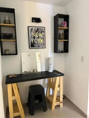 a desk in a room with a mirror and a stool at Departamento Andy in Villa Carlos Paz