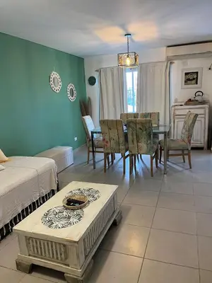 a living room with a table and a dining room at Departamento Andy in Villa Carlos Paz