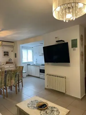 a kitchen and dining room with a television on the wall at Departamento Andy in Villa Carlos Paz