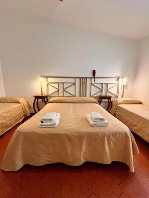 a hotel room with two beds with towels on them at Hotel Mundial in Merlo
