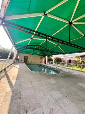 a large green canopy over a swimming pool at Hotel Mundial in Merlo