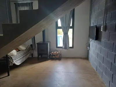 a room with a staircase with a bed and a window at El Descanso in Villa Santa Cruz del Lago