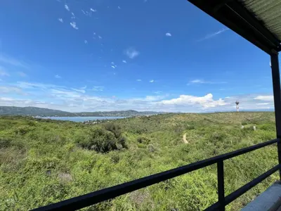 a view from a window of a field and water at El Descanso in Villa Santa Cruz del Lago