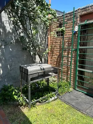 a bench sitting in the grass next to a building at casa kant in Villa Carlos Paz