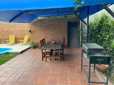a patio with a bbq and a table and a grill at casa kant in Villa Carlos Paz