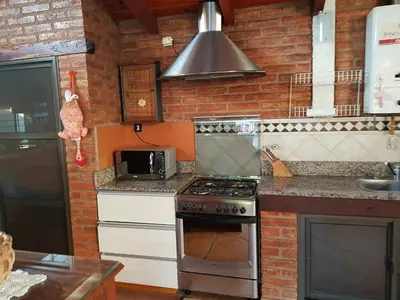 a kitchen with a stove and a microwave at casa kant in Villa Carlos Paz
