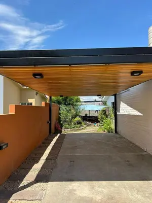 a garage with a black roof on a building at casa kant in Villa Carlos Paz