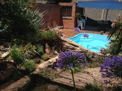 a garden with purple flowers next to a swimming pool at casa kant in Villa Carlos Paz