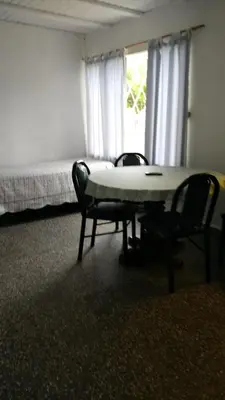 a room with a bed and a table and chairs at Los Duraznos in Villa Cura Brochero