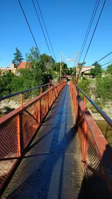 a red bridge over a river with a road at Los Duraznos in Villa Cura Brochero