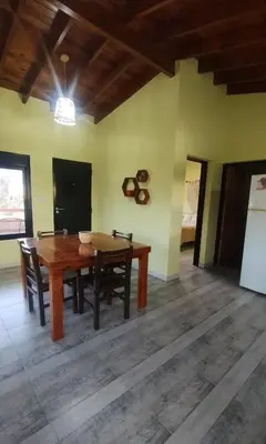 a dining room with a wooden table and chairs at Cabaña Cina Cina in Villa Larca