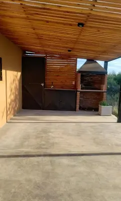a garage with a large black door and a building at Cabaña Cina Cina in Villa Larca