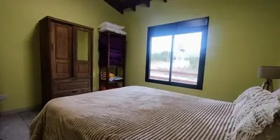 a bedroom with a bed and a window at Cabaña Cina Cina in Villa Larca
