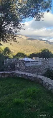 a stone wall with a building in a field at DonPedro in Los Hornillos
