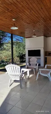 a patio with two white chairs and a fireplace at DonPedro in Los Hornillos