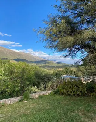 a view of a field with a tree and mountains at DonPedro in Los Hornillos