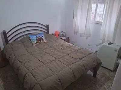 a bedroom with a bed with a brown comforter at Cerro blanco in Villa Carlos Paz