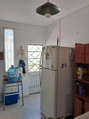 a kitchen with a refrigerator and a table and a window at Cerro blanco in Villa Carlos Paz