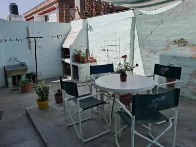 a table and chairs in a patio with plants at Cerro blanco in Villa Carlos Paz