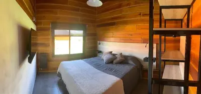 a bedroom with a bed in a wooden cabin at San Yucac Relax in Los Reartes