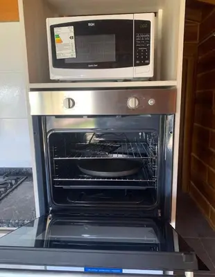 an oven with a microwave on top of it at San Yucac Relax in Los Reartes