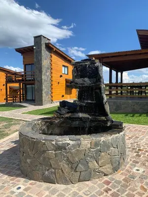 a stone fountain in front of a building at San Yucac Relax in Los Reartes