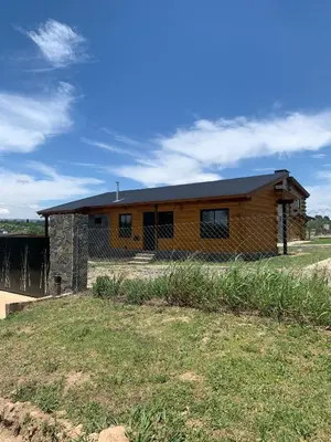 a house on a field with a building at San Yucac Relax in Los Reartes