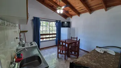 a kitchen with a bed and a table in a room at Hosteria Arture in Villa Cura Brochero