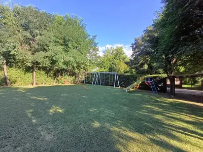 a large yard with a playground with a swing at Hosteria Arture in Villa Cura Brochero