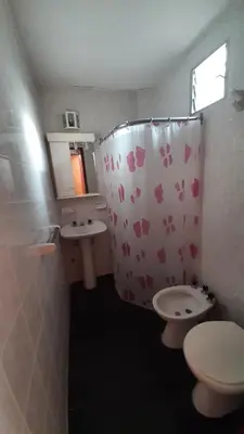 a bathroom with a toilet and a sink and a shower curtain at Hosteria Arture in Villa Cura Brochero