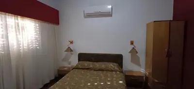 a bedroom with a bed and a air conditioner at Hosteria Arture in Villa Cura Brochero