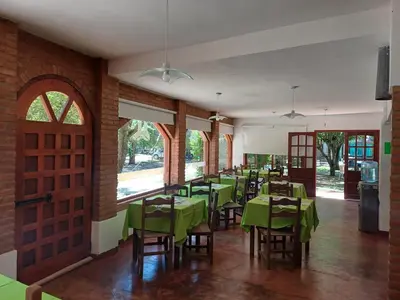 a dining room with green tables and chairs at Hosteria Arture in Villa Cura Brochero