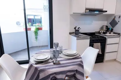 a kitchen with a table with white chairs and a table cloth at Casacalma in Cordoba