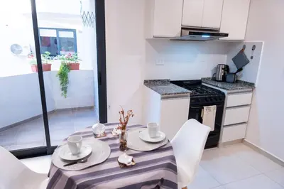 a kitchen with a table with white chairs and a stove at Casacalma in Cordoba