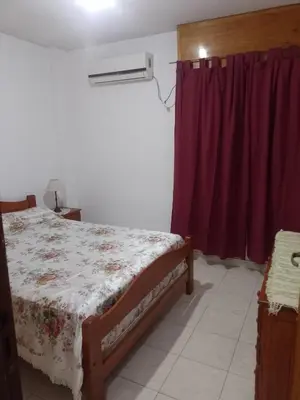 a bedroom with a bed and a red curtain at Tu Refugio Urbano, Confort a metros de la terminal in Villa Carlos Paz