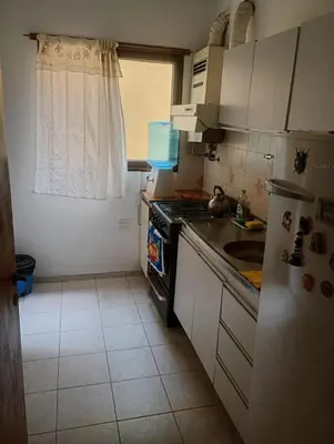 a small kitchen with a stove and a sink at Tu Refugio Urbano, Confort a metros de la terminal in Villa Carlos Paz