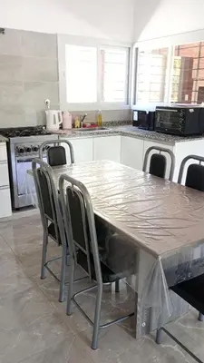 a kitchen with a table and chairs in a kitchen at Chalet Arredondo Villa Carlos Paz in Villa Carlos Paz