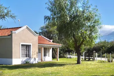 a small house with a tree in the yard at El Cardal in Merlo