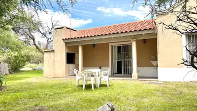 a house with a table and chairs in the yard at El Cardal in Merlo