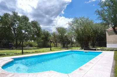 a swimming pool in a yard with a fence at El Cardal in Merlo