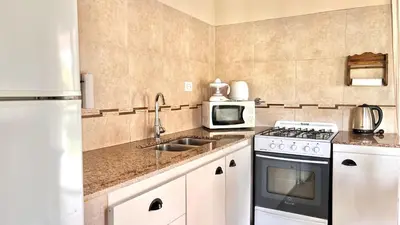 a kitchen with a stove and a microwave at El Cardal in Merlo