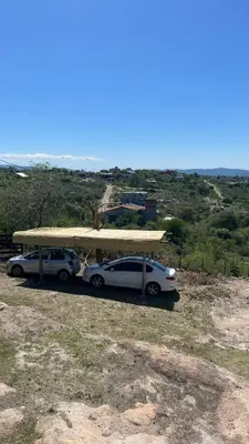 two cars parked under a shelter on top of a hill at Casa en flor serrana in Cavalango