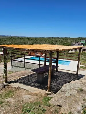 a wooden picnic table sitting next to a pool at Casa en flor serrana in Cavalango