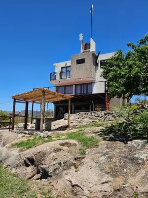 a house sitting on top of a rocky hill at Casa en flor serrana in Cavalango