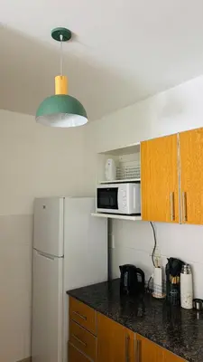 a kitchen with a white refrigerator and a microwave at Departamento centrico amoblado in Río Cuarto