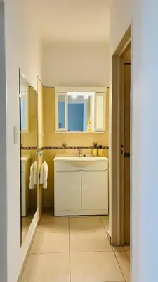 a white kitchen with a sink and a mirror at Departamento centrico amoblado in Río Cuarto