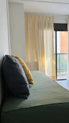 a bed with two pillows on it with a window at Departamento centrico amoblado in Río Cuarto